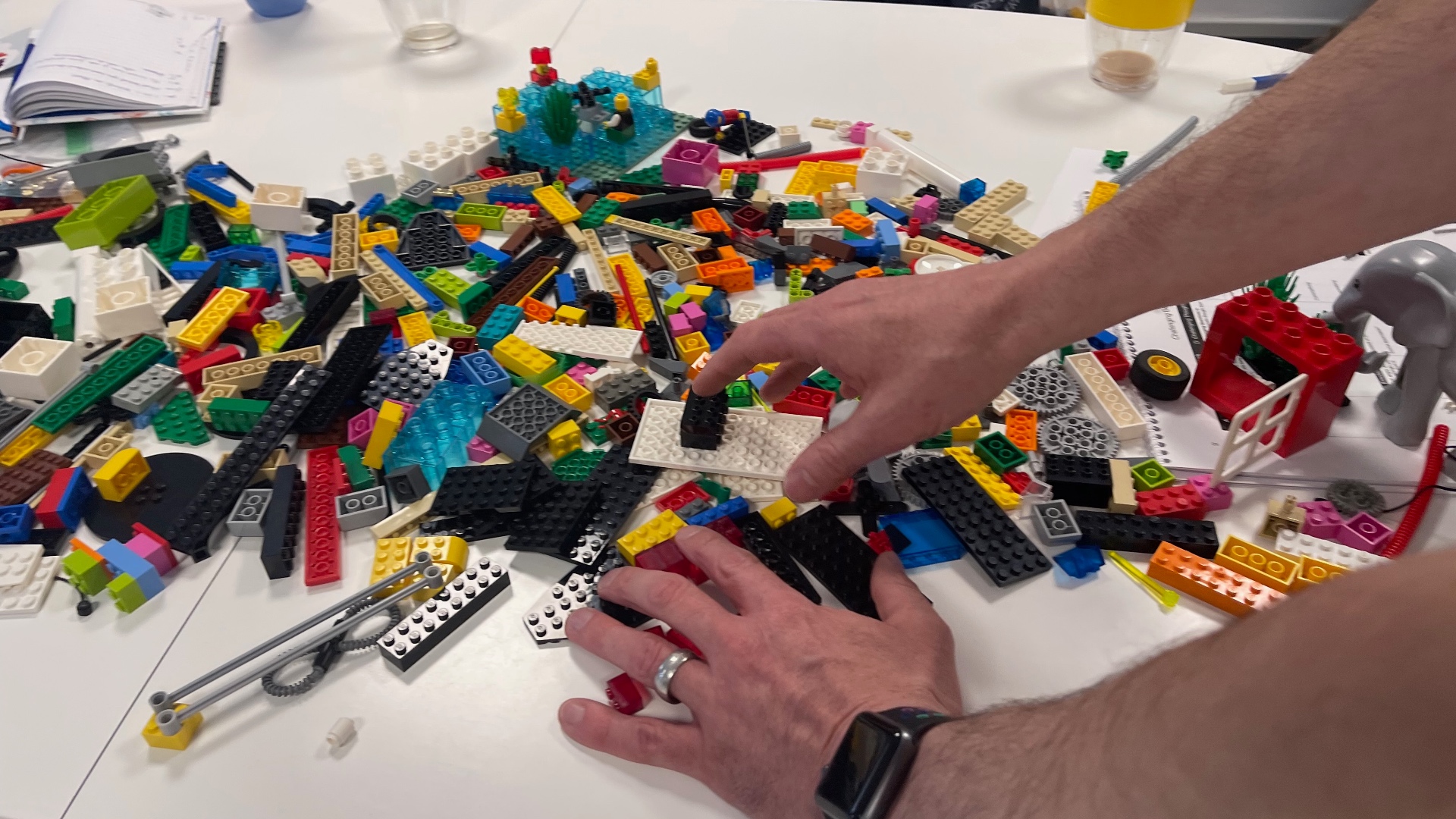 A participant selecting bricks from a shared pile during a facilitated workshop