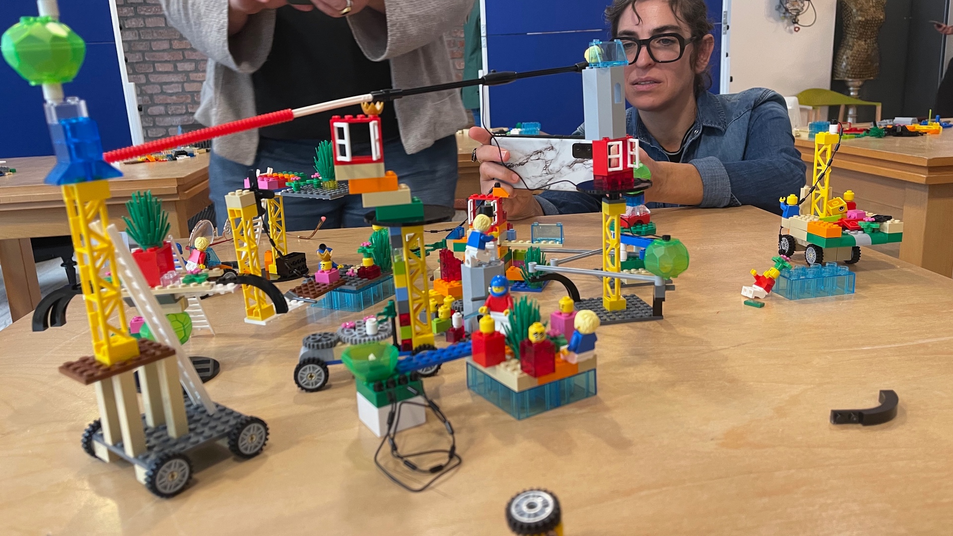 Participants photographing and discussing a shared model built by the whole group